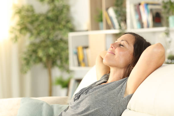 Happy adult woman relaxing in the sofa at home